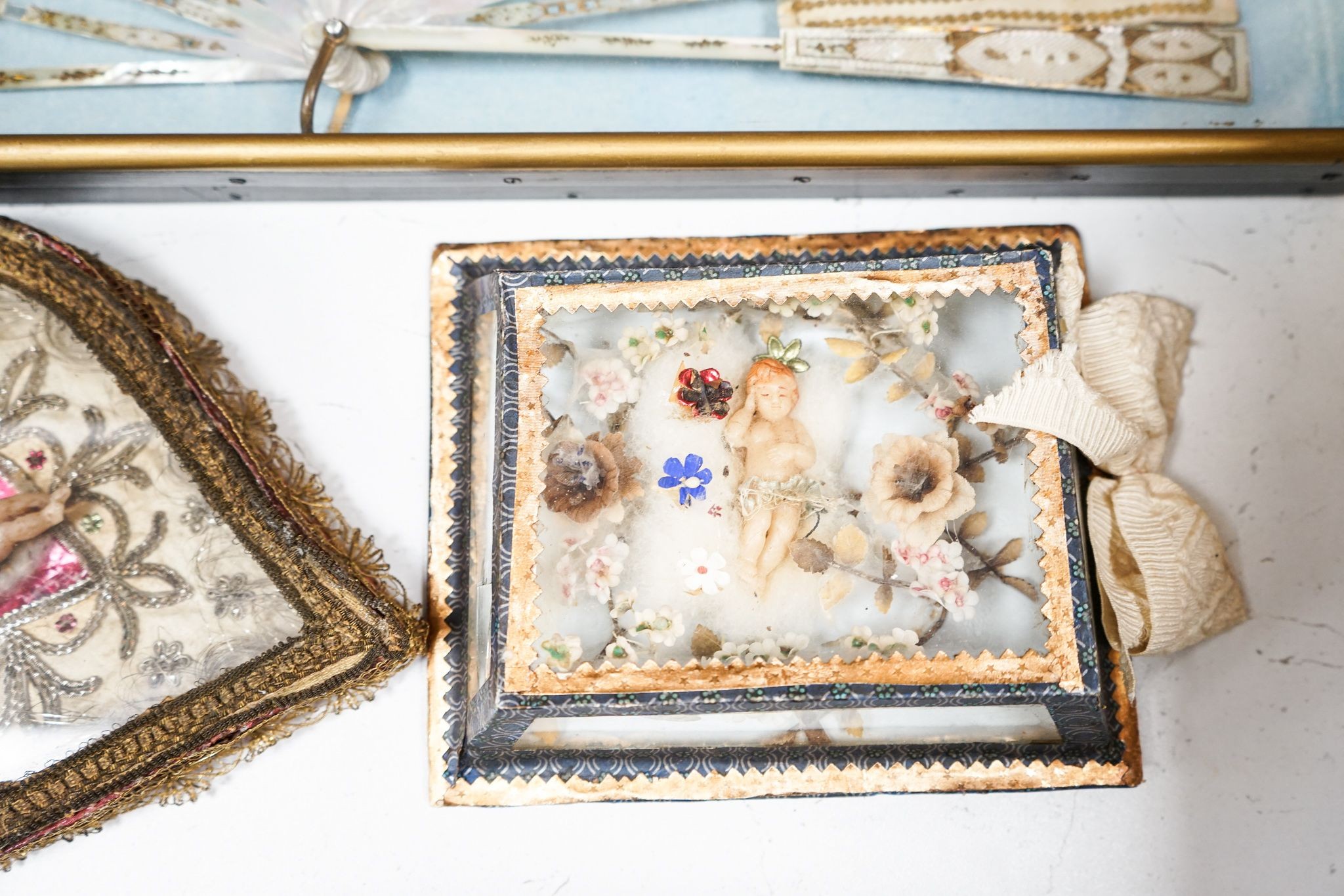 A late 18th / early 19th century Continental figurative framed fan and two religious cased effigy of baby Jesus